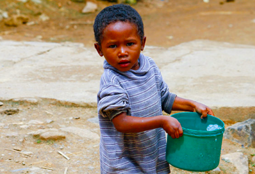 Boy holding fresh water from air in bucket